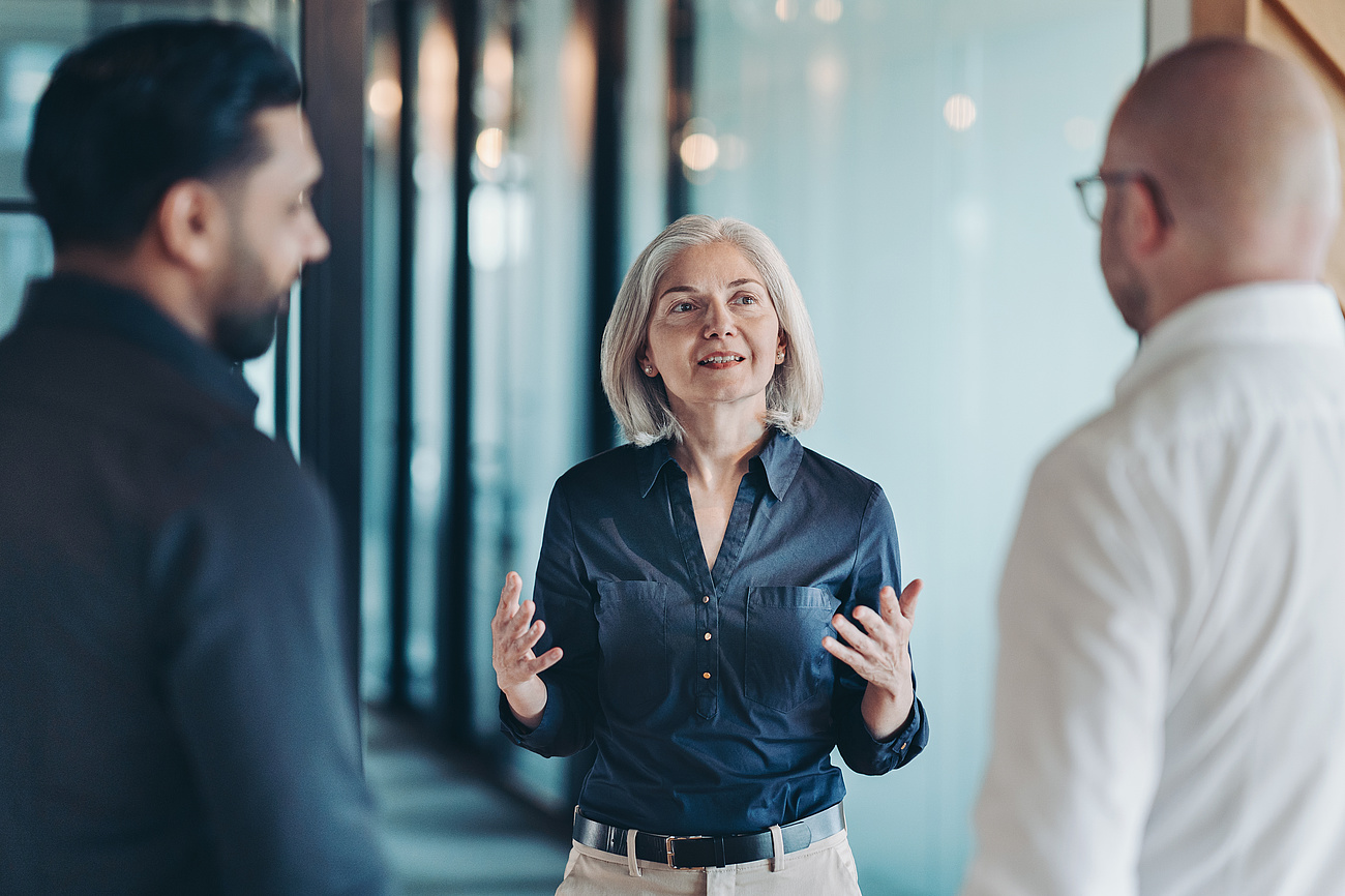 Weibliche Führungskraft im Gespräch mit Kollegen